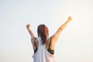 woman raising arms in the air with fists clenched