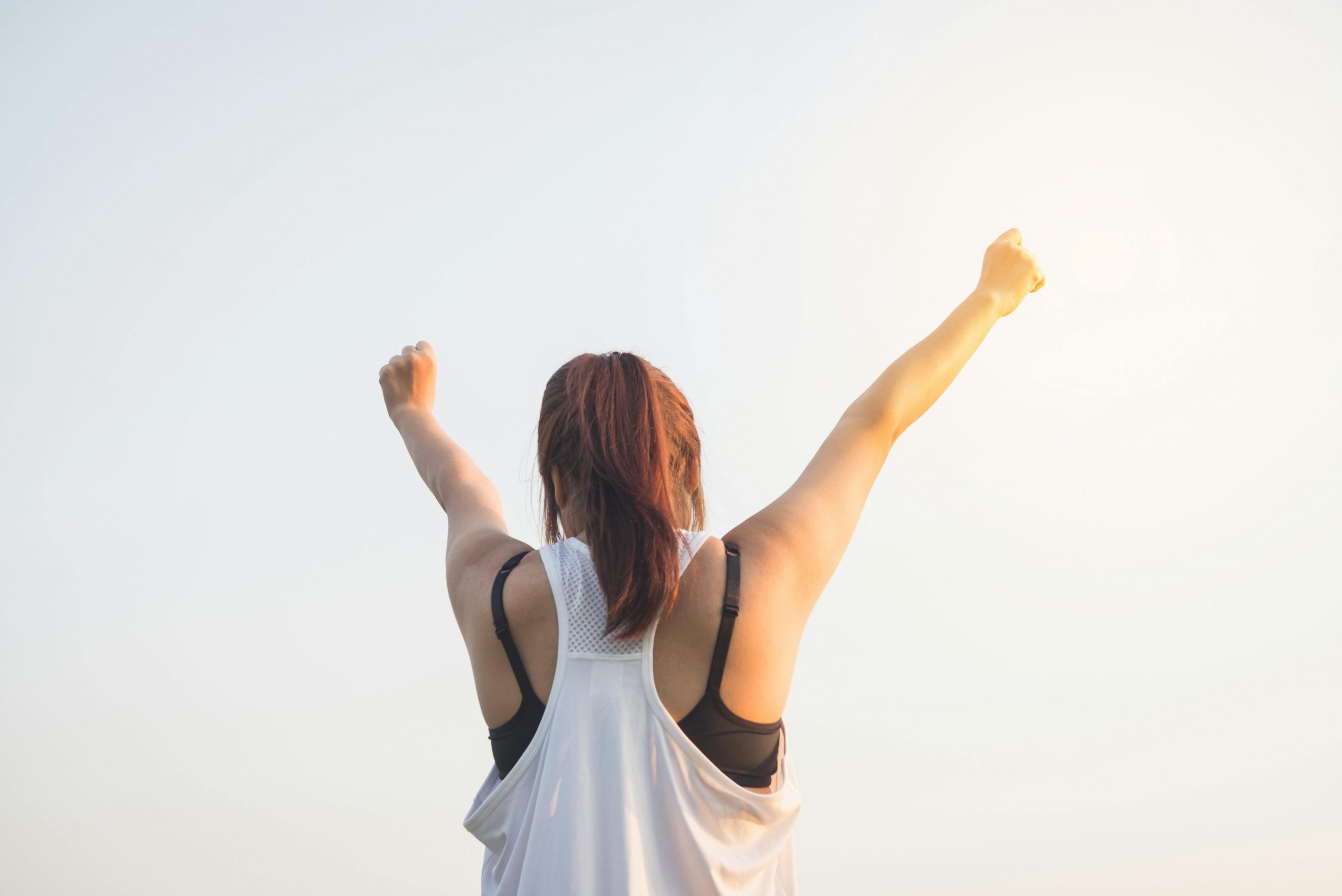 woman raising arms in the air with fists clenched