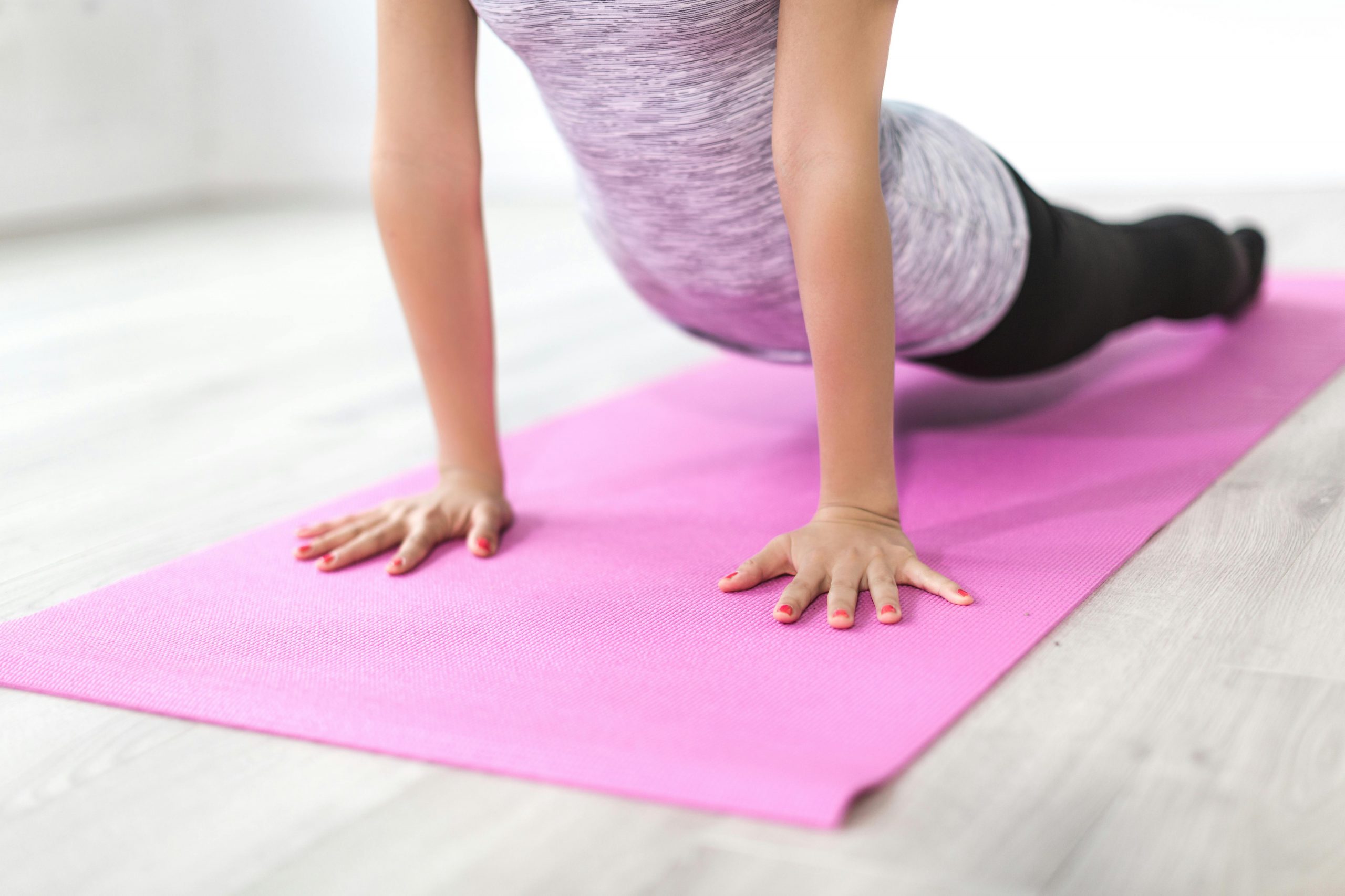 woman doing somatic exercises on a pink yoga mat
